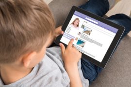 60368661 - close-up of cute little boy using social networking site on digital tablet at home