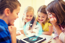48512750 - education, elementary school, learning, technology and people concept - group of school kids looking to tablet pc computer screen with globe hologram on break in classroom