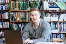 38191955 - young male student typing on laptop in the university library