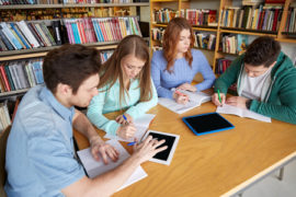 52989864 - people, knowledge, education and school concept - group of students with tablet pc computers writing to notebooks in library
